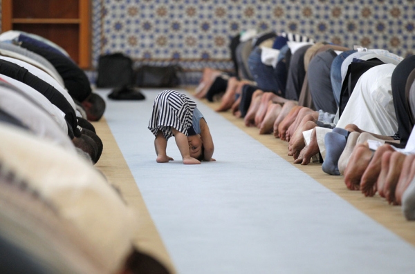 Un enfant imite les adultes durant la prière de midi à la Grande Mosquée de Strasbourg.